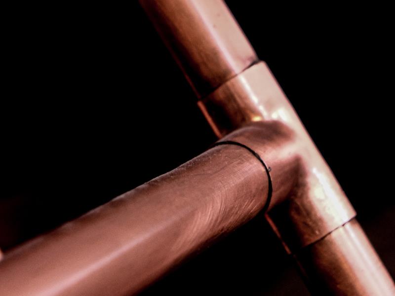 A copper pipes joined in a t-shape.