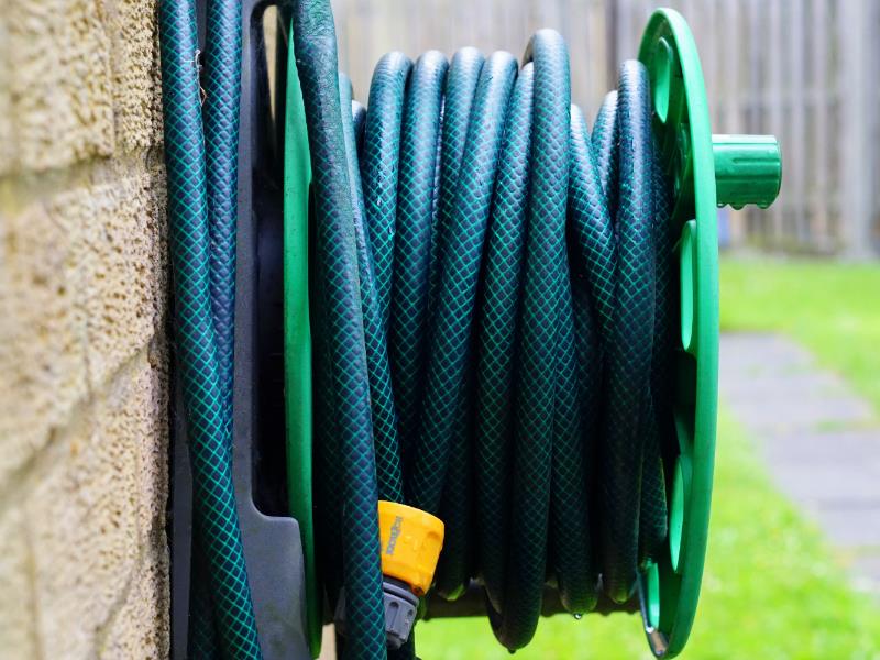 A coiled garden hose stored for easy access