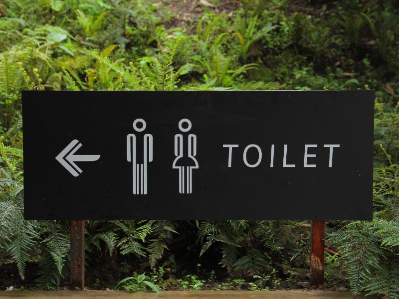 An English-Language sign navigating readers to a nearby public bathroom